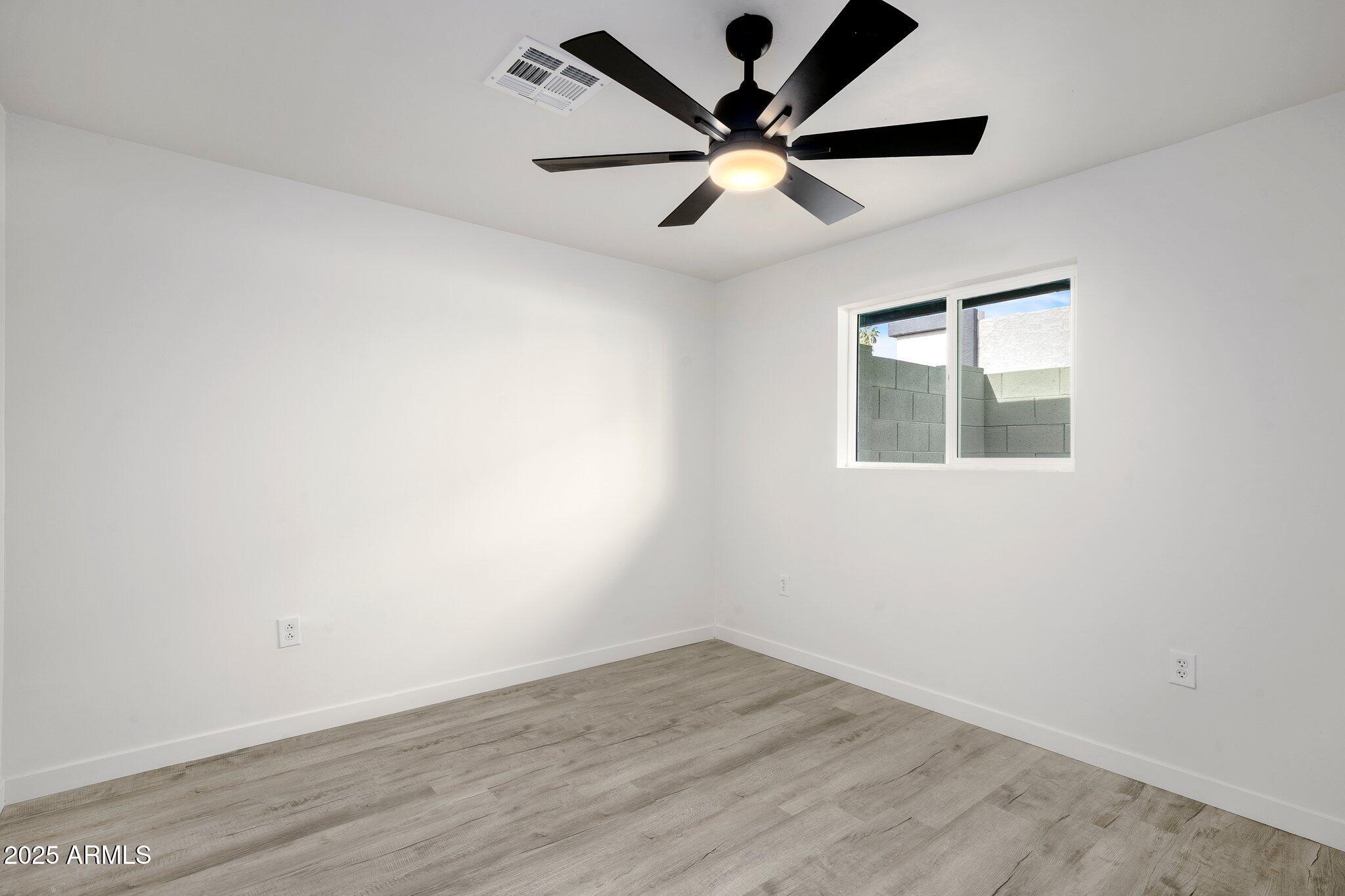 3114 North 68th Street, Unit 2 Scottsdale, AZ 85251 - Photo 8 of 25 an empty room with wooden floor and windows
