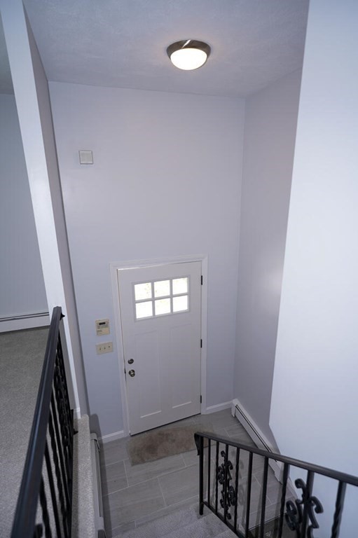 3 Rickey Drive Maynard, MA 01754 - Photo 11 of 25 a view of a hallway with wooden floor and stairs