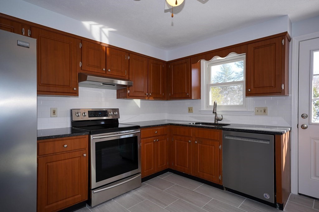 3 Rickey Drive Maynard, MA 01754 - Photo 3 of 25 a kitchen with stainless steel appliances granite countertop wooden cabinets a sink and a stove