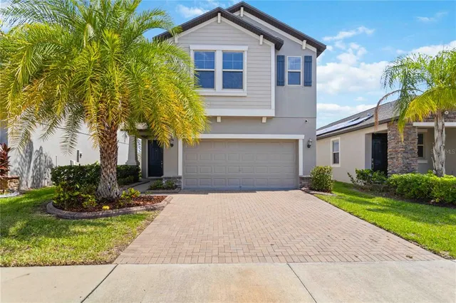 a front view of a house with a yard and trees