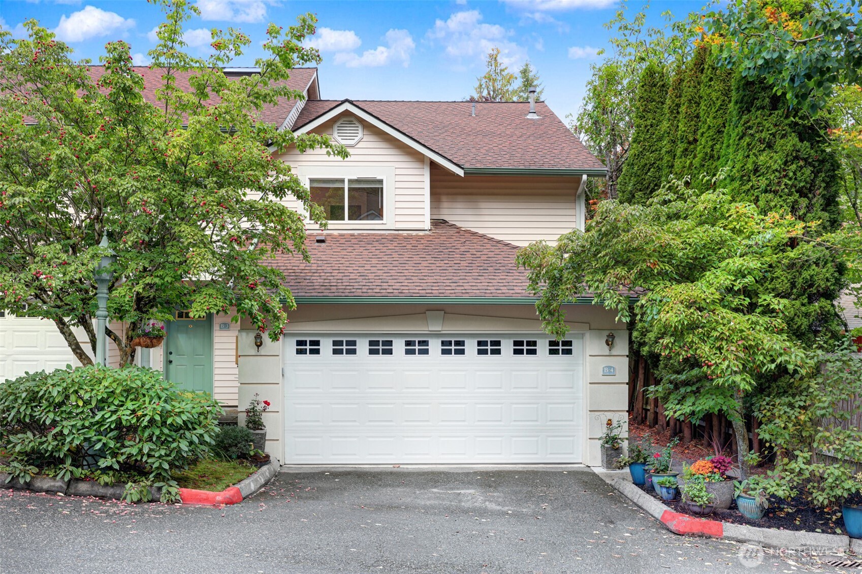 8828 238th Street Southwest, Unit B4 Edmonds, WA 98026 - Photo 30 of 37 a view of a white house with large windows and a small yard