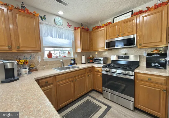 a kitchen with stainless steel appliances granite countertop a stove sink and cabinets
