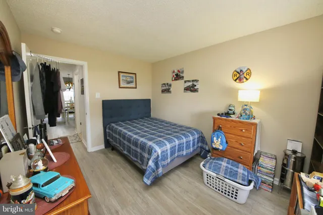 a bedroom with a bed and a flat tv screen on dresser