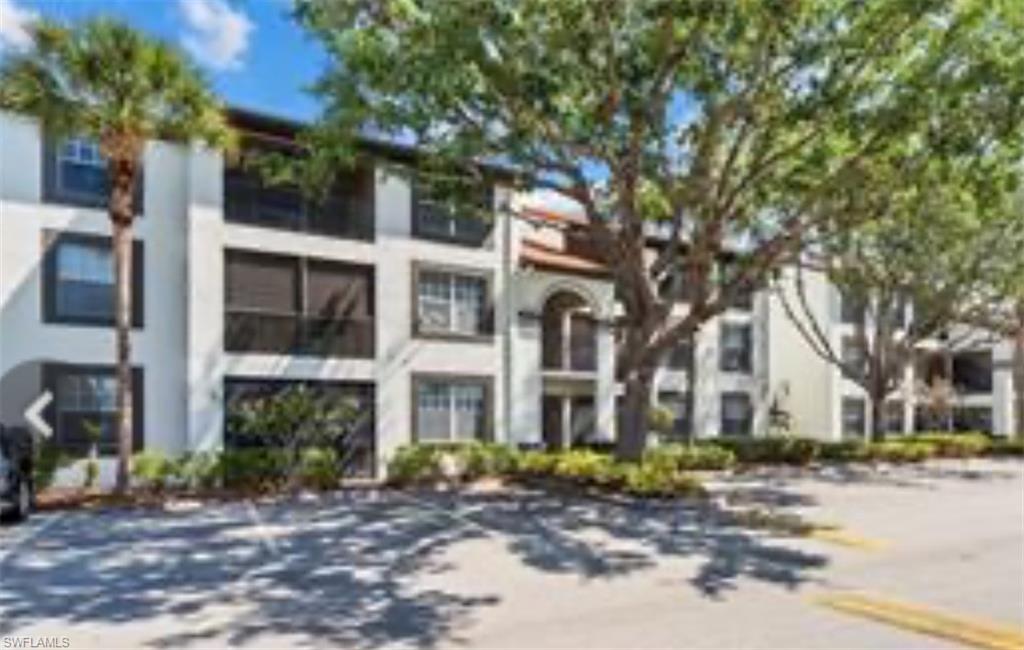 7940 Preserve Circle, Unit 914 Naples, FL 34119 - Photo 1 of 16 a view of a brick house with a yard and large tree