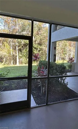 a view of a room with wooden floor and a floor to ceiling window