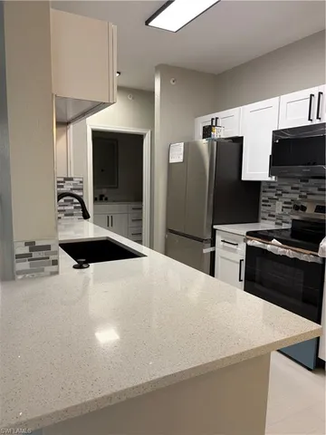 a kitchen with stainless steel appliances a microwave a sink and a refrigerator