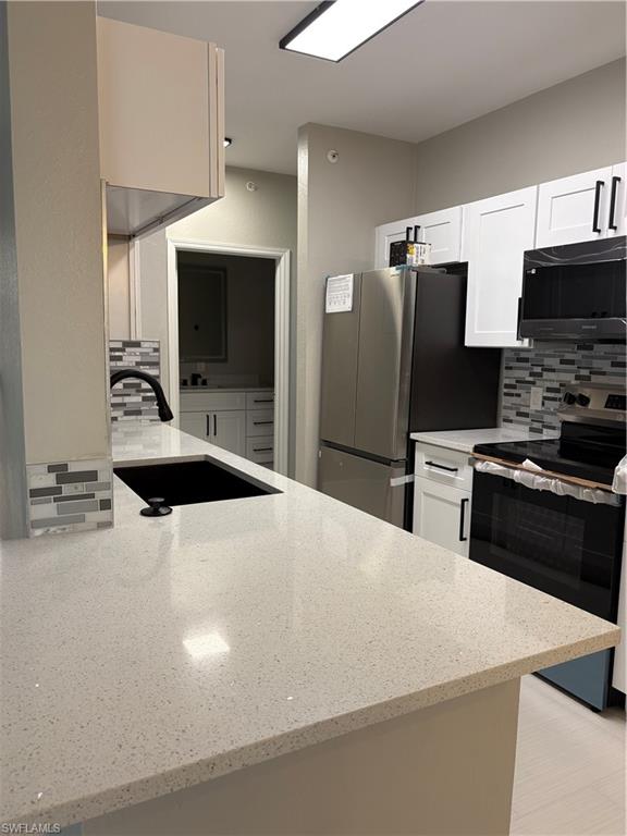 7940 Preserve Circle, Unit 914 Naples, FL 34119 - Photo 2 of 16 a kitchen with stainless steel appliances a microwave a sink and a refrigerator