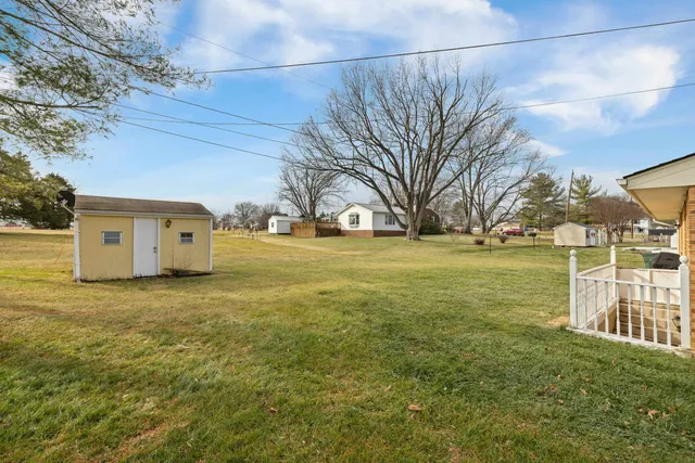 a view of a big house with a big yard and large tree