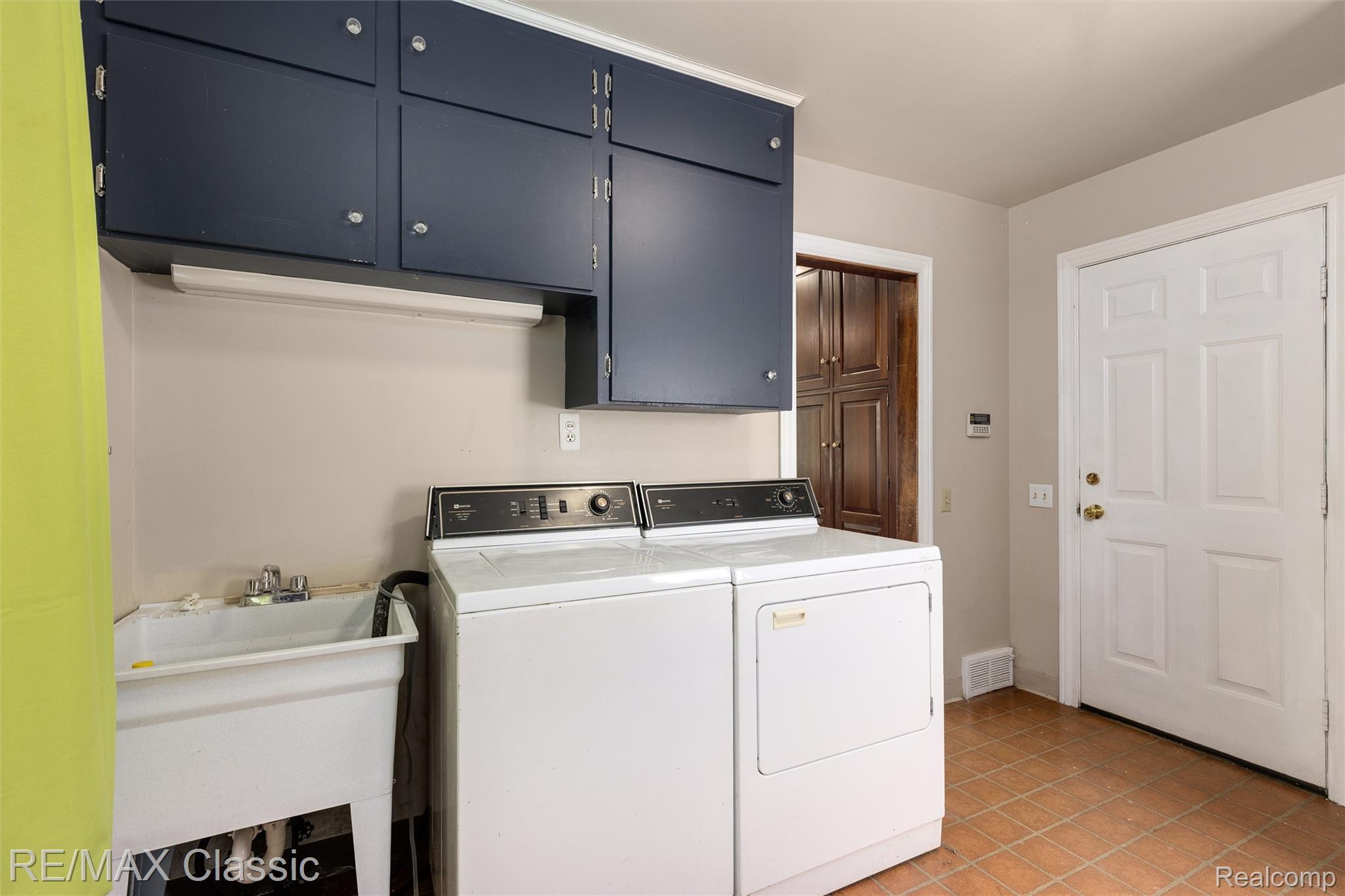 4268 Covered Bridge Road Bloomfield Hills, MI 48302 - Photo 28 of 35 Laundry area with dark blue upper cabinetry and a utility sink
