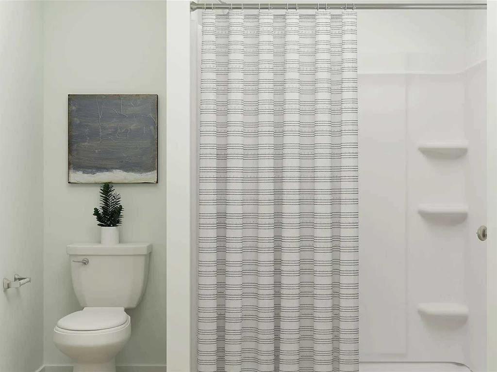 11345 Rodeo Drive Providence Village, TX 76227 - Photo 13 of 32 a bathroom with a toilet and a shower curtain