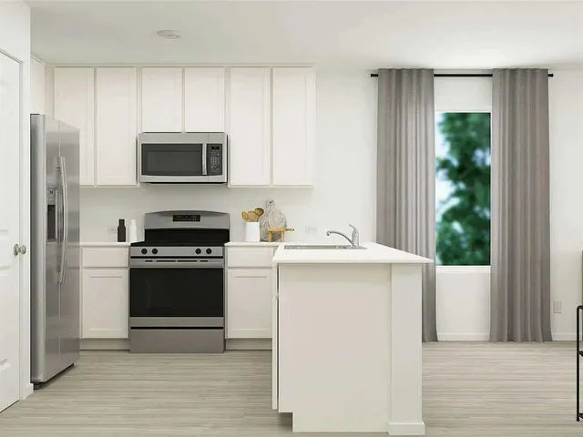 a kitchen with stainless steel appliances a stove microwave and refrigerator
