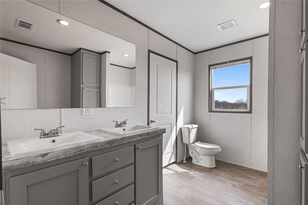 3888 Sandusky Road Whitesboro, TX 76273 - Photo 19 of 24 Bathroom featuring double vanity, crown molding, light wood-style floors, recessed lighting, and backsplash