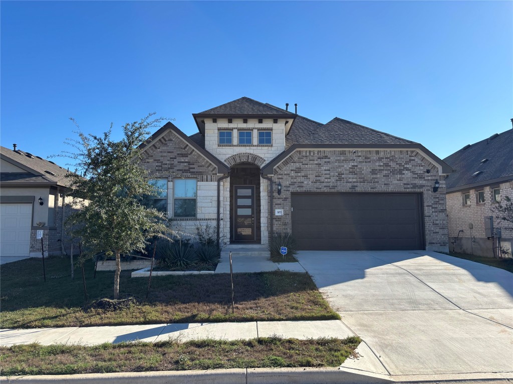 a front view of a house with a yard and garage