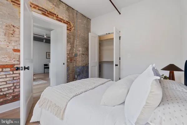 a bedroom with a bed and closet with chair