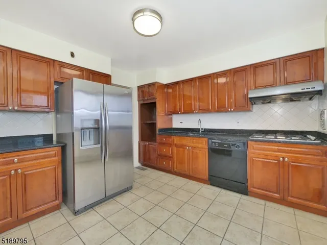 a kitchen with stainless steel appliances granite countertop a refrigerator sink and cabinets