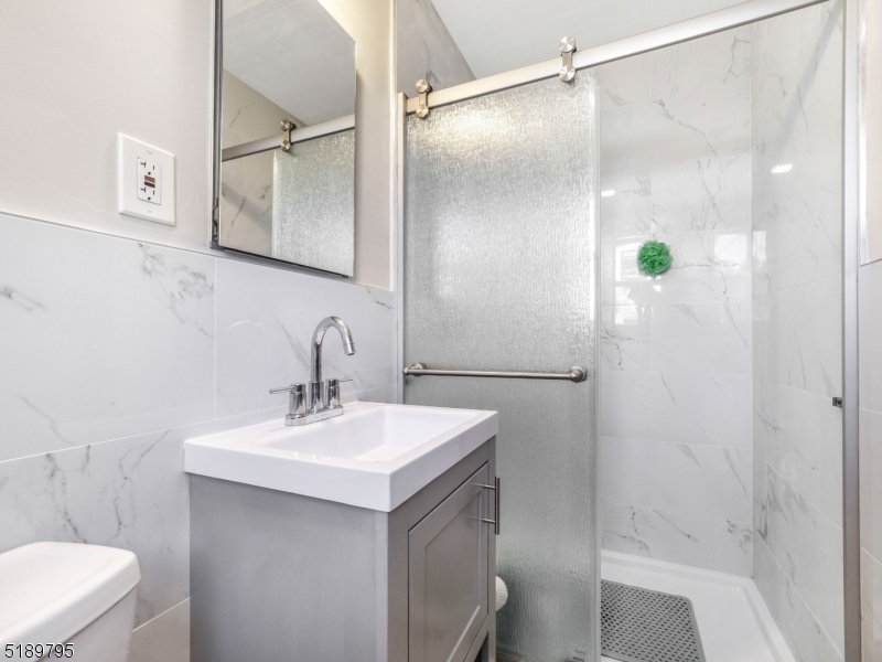 69 Rector Street Millburn, NJ 07041 - Photo 21 of 29 a bathroom with a sink mirror and a shower