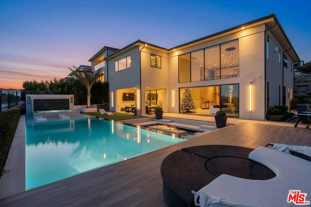 a view of a house with swimming pool and sitting area
