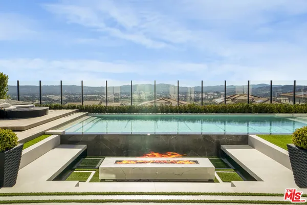 a view of a swimming pool with lawn chairs and a yard