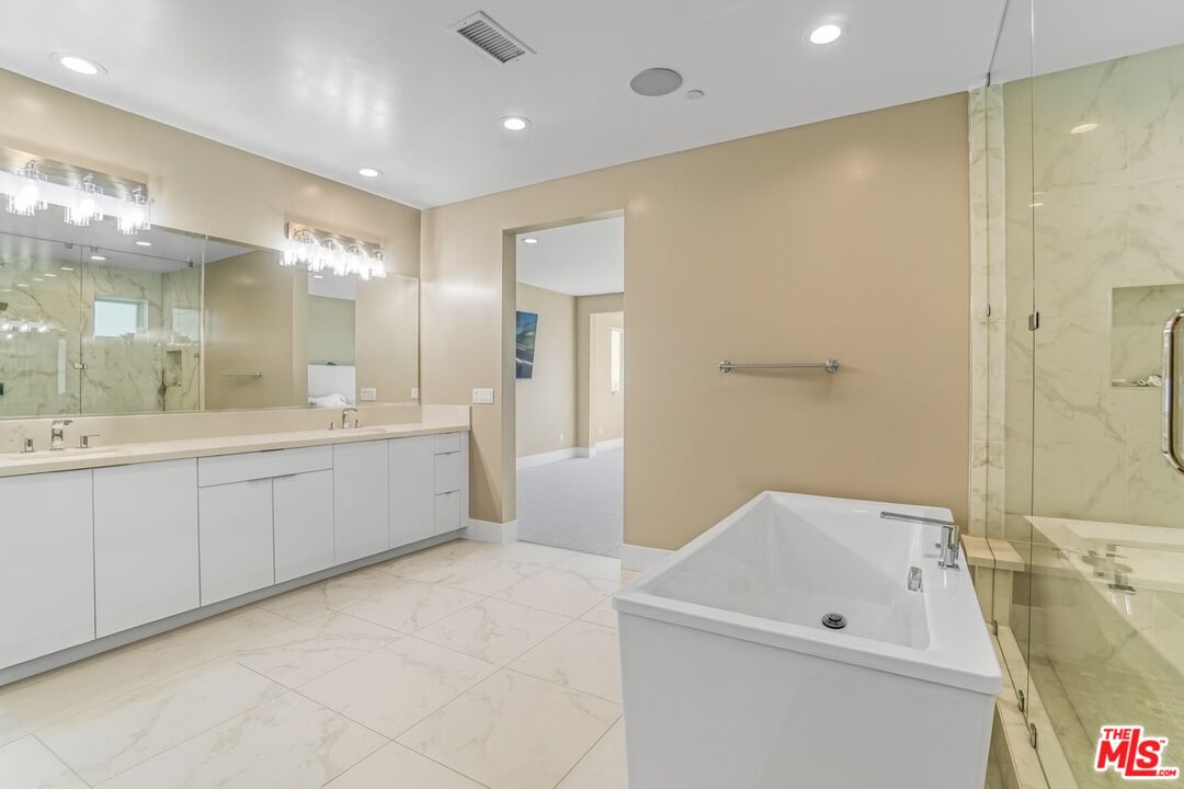 20306 Willoughby Lane Porter Ranch, CA 91326 - Photo 30 of 40 a spacious bathroom with a tub sink shower and mirror