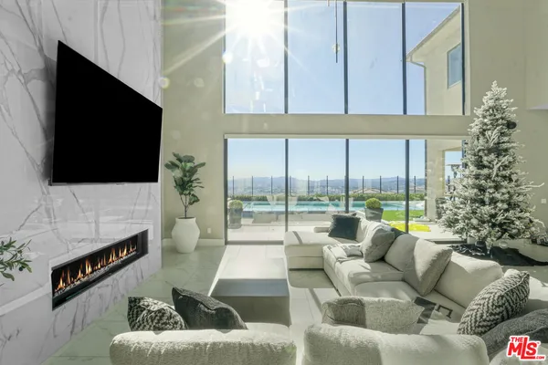 a living room with furniture a flat screen tv and a floor to ceiling window