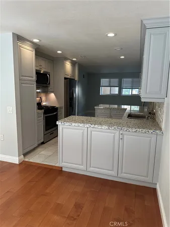 a kitchen with kitchen island granite countertop a stove and a refrigerator