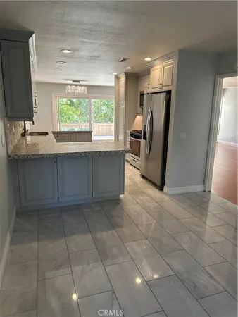a view of kitchen with granite countertop a sink a counter top space and cabinets