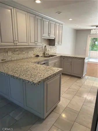 a kitchen with granite countertop a sink a stove a microwave and cabinets