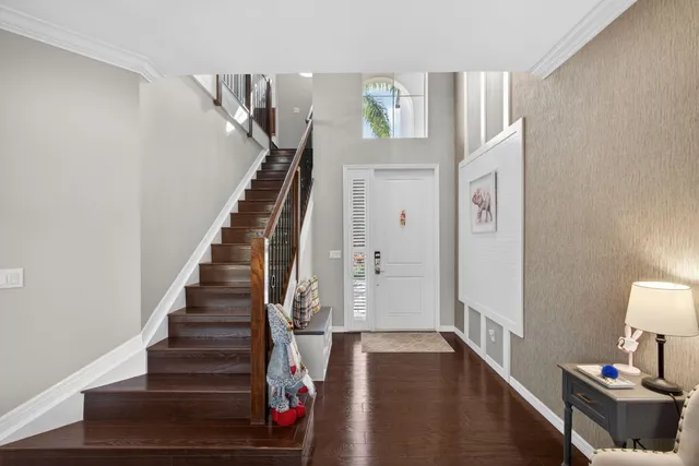 a view of a hallway with entryway and wooden floor