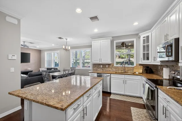 a kitchen with stainless steel appliances granite countertop a sink stove and cabinets