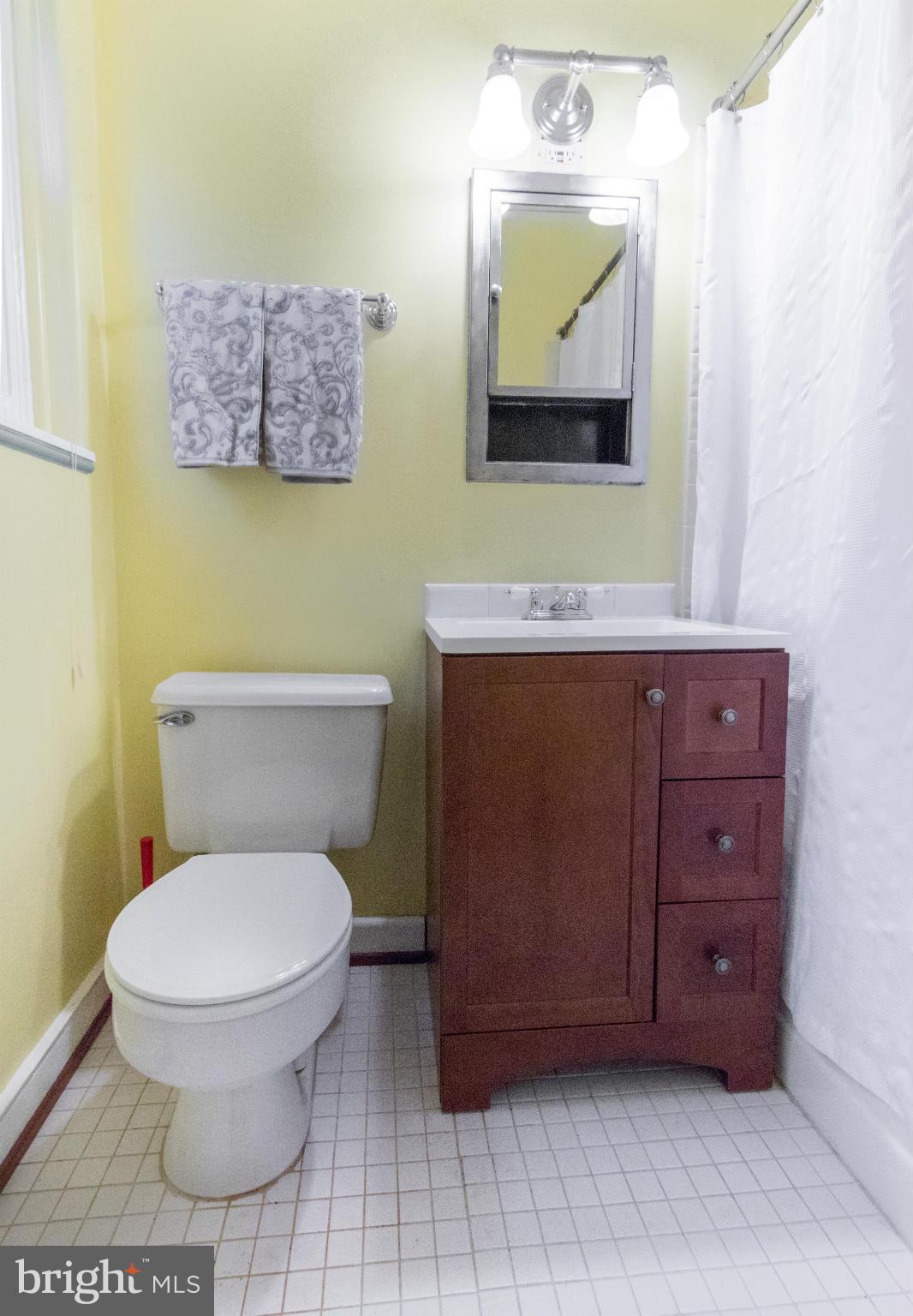 3 Crescent Road, Unit B Greenbelt, MD 20770 - Photo 11 of 22 a bathroom with a toilet a sink and mirror