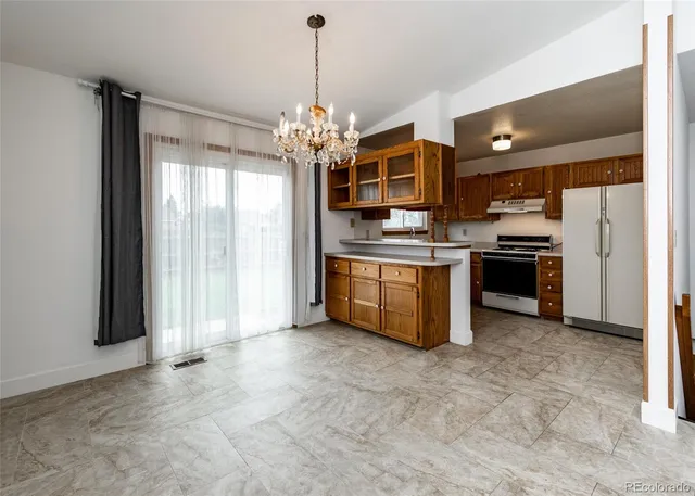 a view of a kitchen with a sink and dishwasher a refrigerator with wooden floor