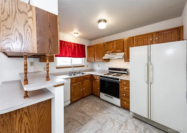 a kitchen with stainless steel appliances granite countertop a refrigerator sink and stove