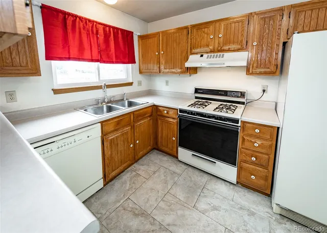 a kitchen with a stove a sink and a refrigerator