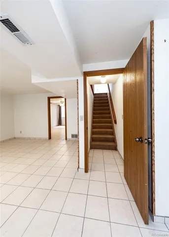 a view of a hallway with wooden floor and stairs