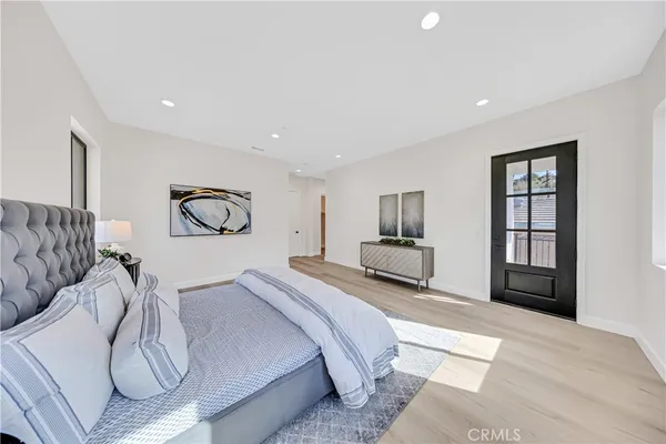 a spacious bedroom with a bed a table and chair