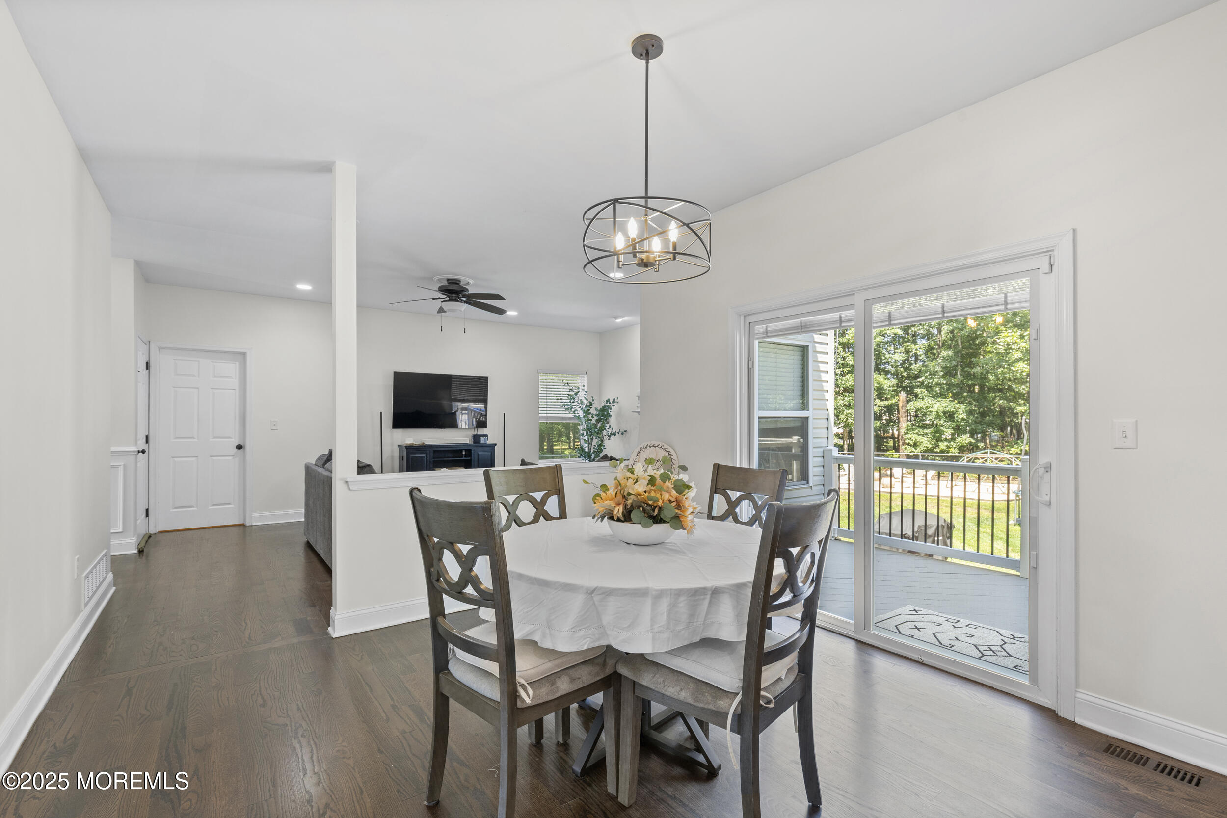 6 Kindling Way Jackson, NJ 08527 - Photo 18 of 54 a dining room with wooden floor a chandelier a wooden table and chairs