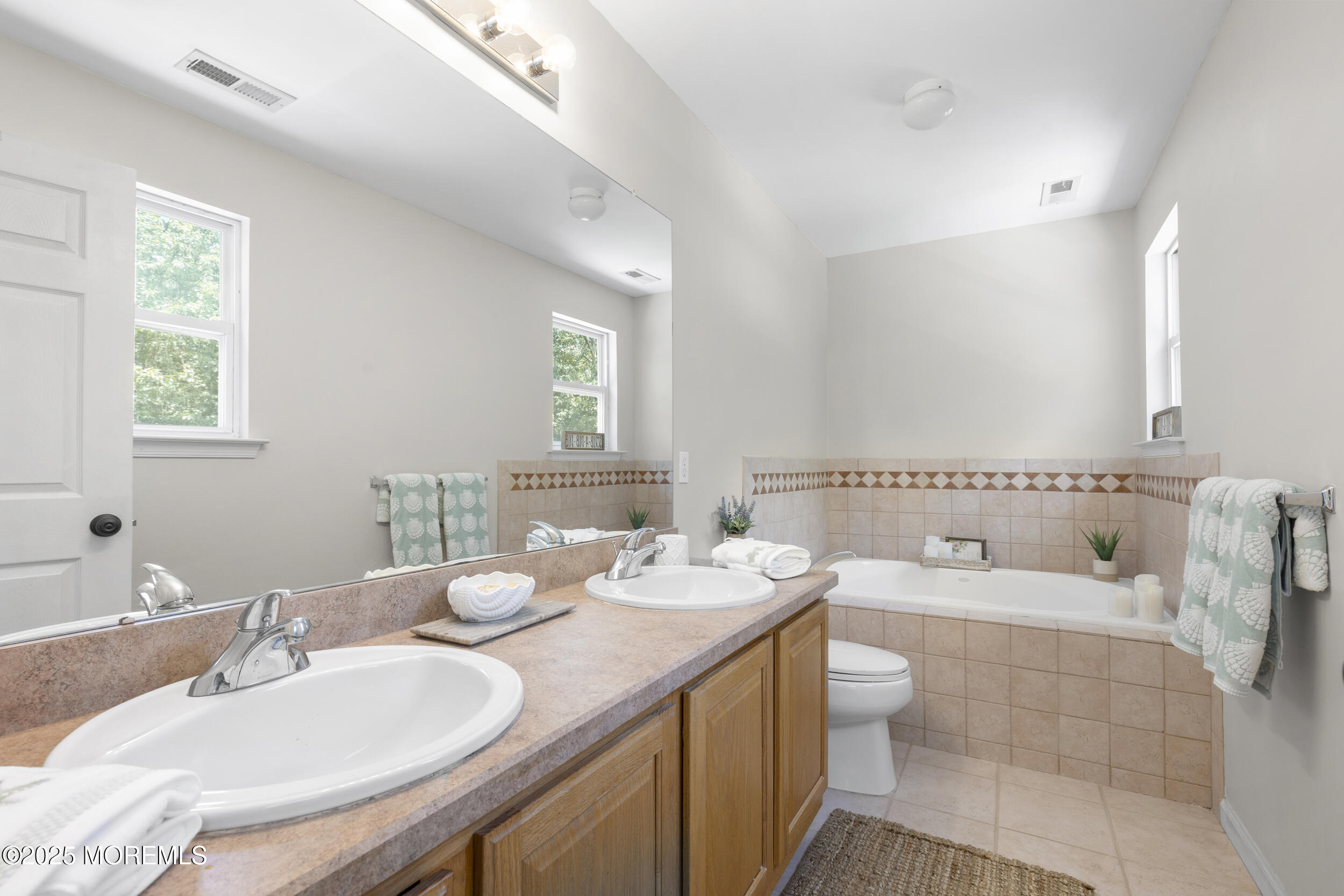 6 Kindling Way Jackson, NJ 08527 - Photo 30 of 54 a bathroom with a granite countertop double vanity sinks a mirror and a bathtub