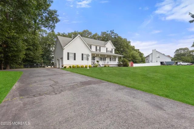 a view of a house with a big yard and large trees