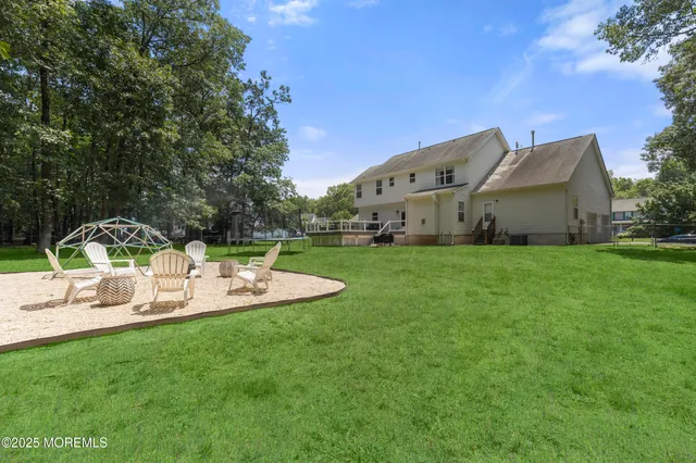 an aerial view of a house with a yard and trees all around