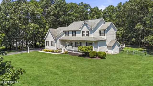 an aerial view of a house with a yard and lake view