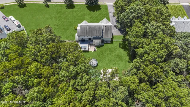 an aerial view of residential houses with outdoor space and trees