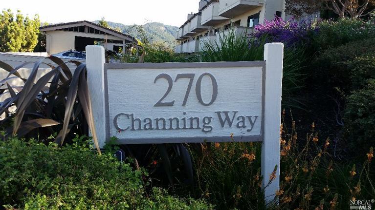a view of sign board with buildings and plants
