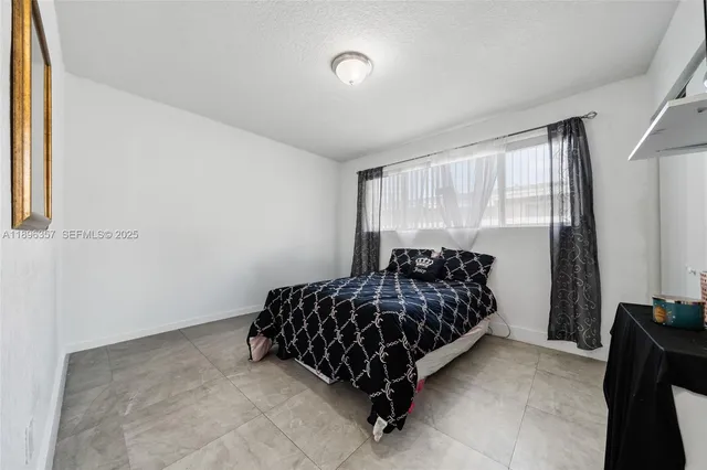 a bed sitting in a bedroom next to a window
