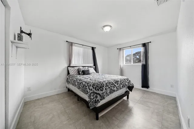 a bedroom with a bed lamp and a window