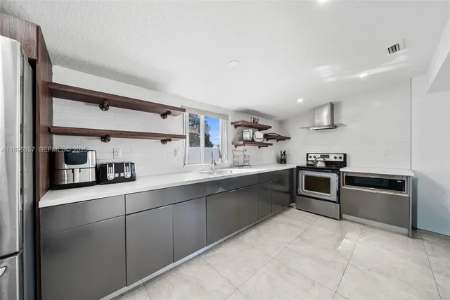 a kitchen with stainless steel appliances granite countertop a sink and stove top oven