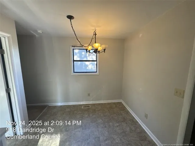 an empty room with a ceiling fan and wooden floor