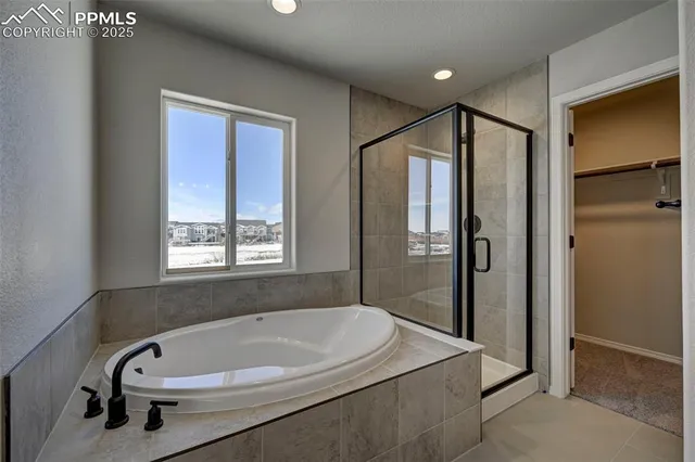 a bathroom with a tub a sink and a large window