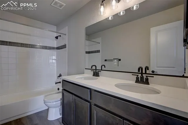 a bathroom with a sink a toilet a mirror a bathtub and shower