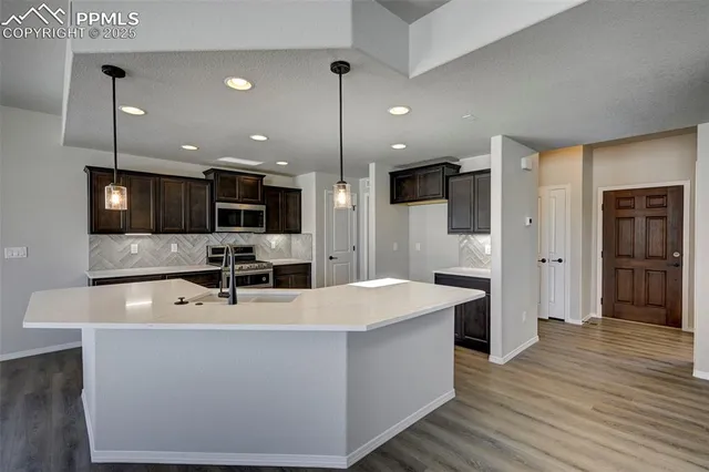 a large kitchen with stainless steel appliances a large counter top oven and cabinets