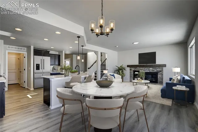 a view of a dining room with furniture a fireplace and wooden floor